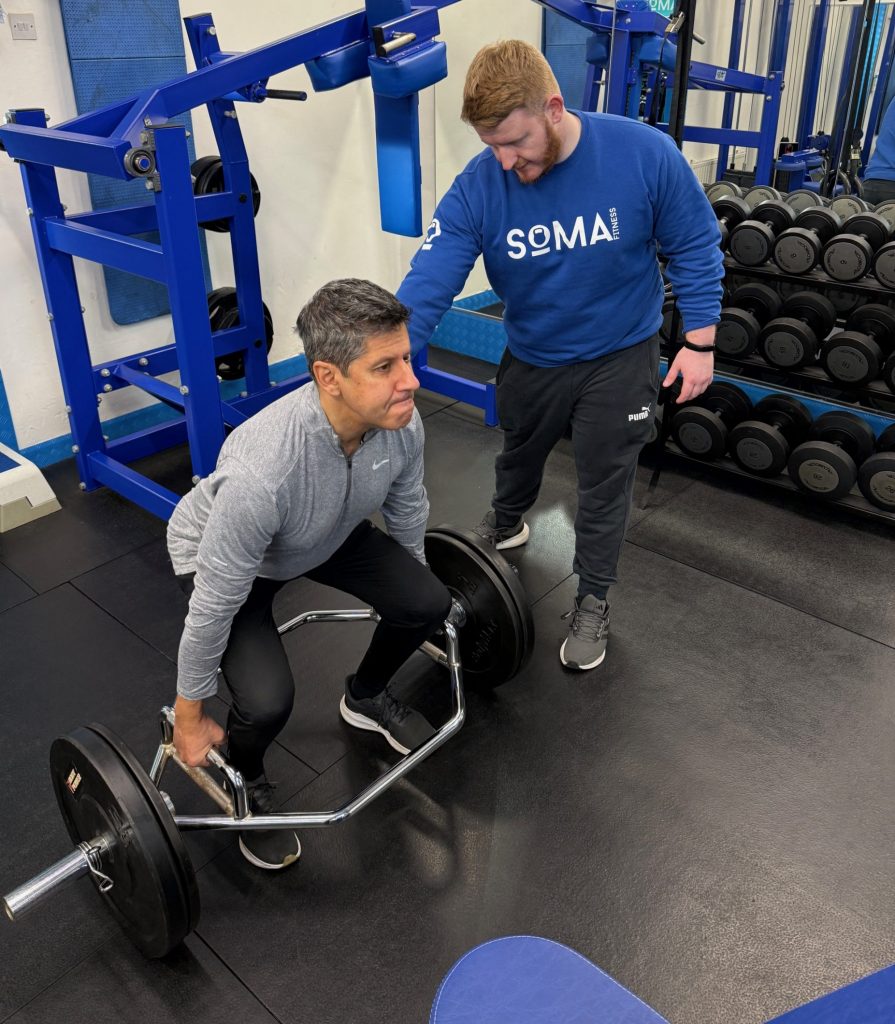 Personal Training for Men Over 50 in Altrincham | Soma Fitness Personal trainer coaching a man over 50 during strength training at Soma Fitness in Altrincham