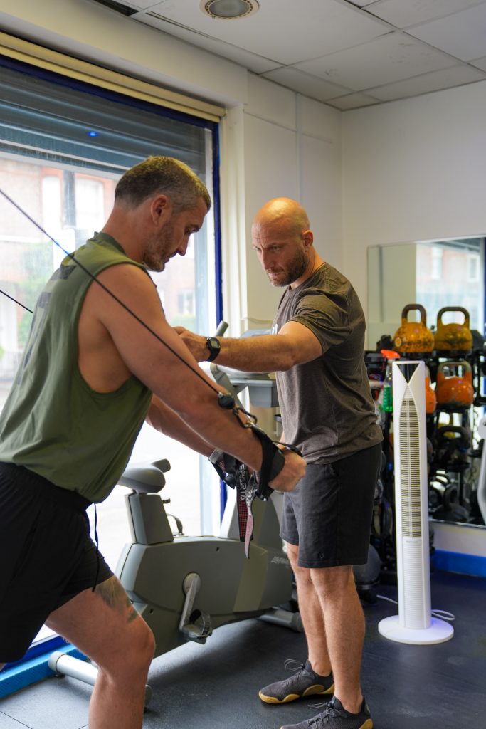 Personal trainer coaching a client through strength training at Soma Fitness in Altrincham