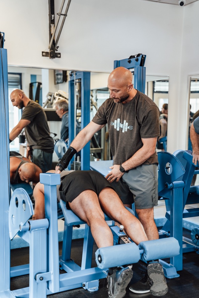 Personal trainer coaching a client through lower-body strength training at Soma Fitness in Altrincham